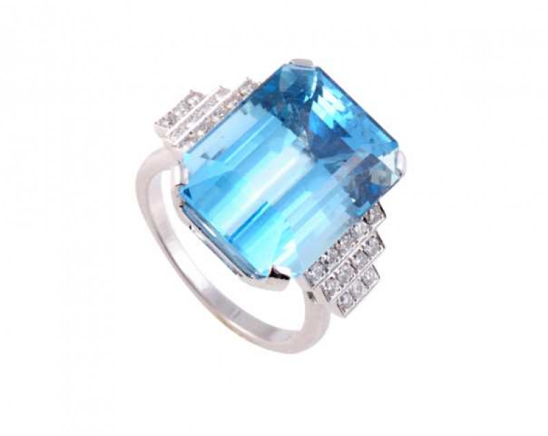 An aquamarine and diamond ring, the large rectangular cut aquamarine four claw set between stepped shoulders each set with twelve brilliant cut diamond highlights, all set in an open mount on a plain band. Stamped 18CT. Ring size O.