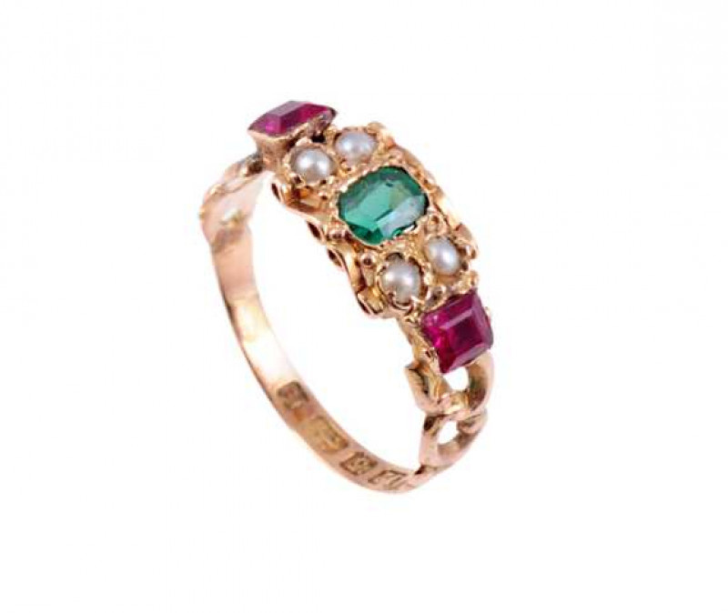 A seed pearl, emerald and ruby ring, circa 1840, the square cut emerald collet set to the centre of a heavily moulded detail mount of scroll work and beaded detail, set to each shoulder with two seed pearls and a square cut collet set ruby, set between si
