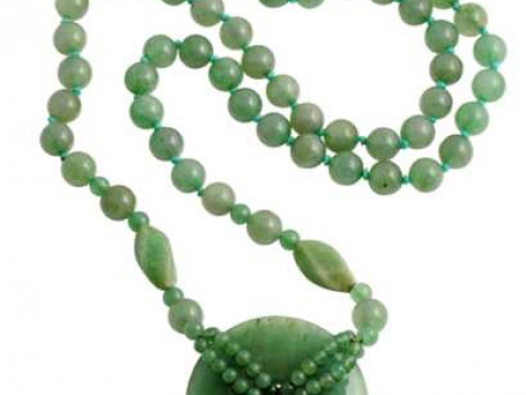 A jadeite necklace, the sixty seven beads suspending a larger disc shaped...