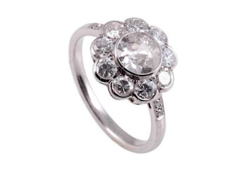 A diamond ring, the central old brilliant cut diamond collet set within...