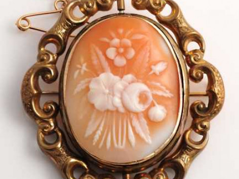 An mid Victorian cameo brooch, the oval cameo depicting a floral scene,...