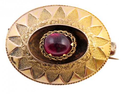 A mid Victorian garnet brooch, set to the centre with an oval cabochon...