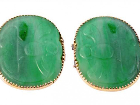 A pair of jadeite plaques, each oval plaque subtly carved with a winged...