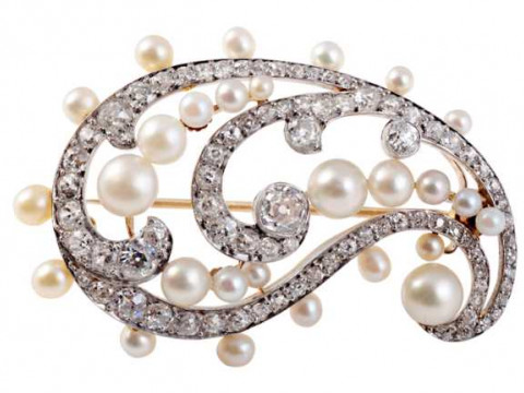 A late Edwardian pearl and diamond brooch, the delicate swirl design set...