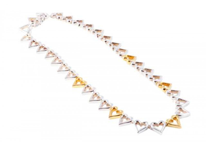 Ilias Lalaounis: A silver and yellow coloured metal necklace, the thirty five identical open heart links all articulated, five evenly spaced heart links to the bottom in differing yellow coloured metal, all held by an integral tongue clasp with figure 8 s