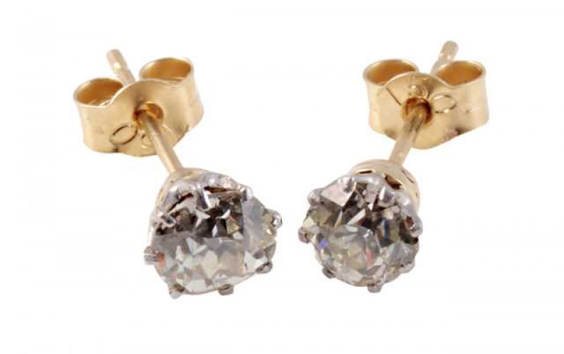 A pair of simple diamond ear studs, the old brilliant cut diamonds eight claw set in pierced detail mounts on post and scroll fittings. Scrolls stamped 750. Weight of one earring approx. 0.7gms.