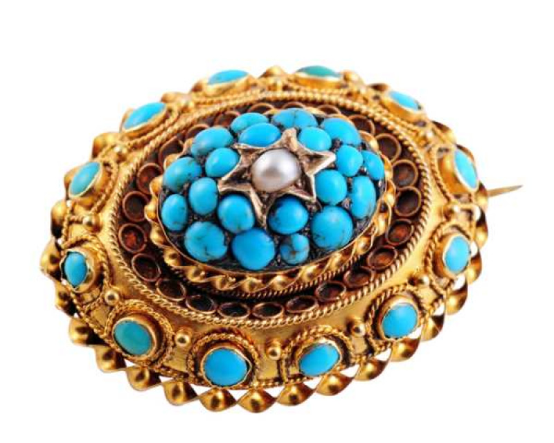A mid Victorian turquoise and seed pearl hair locket mourning brooch, the raised oval mount set to the top with a single seed pearl highlight in a star shaped mount, within a surround of twenty turquoise highlights, all within an elaborately detailed moun