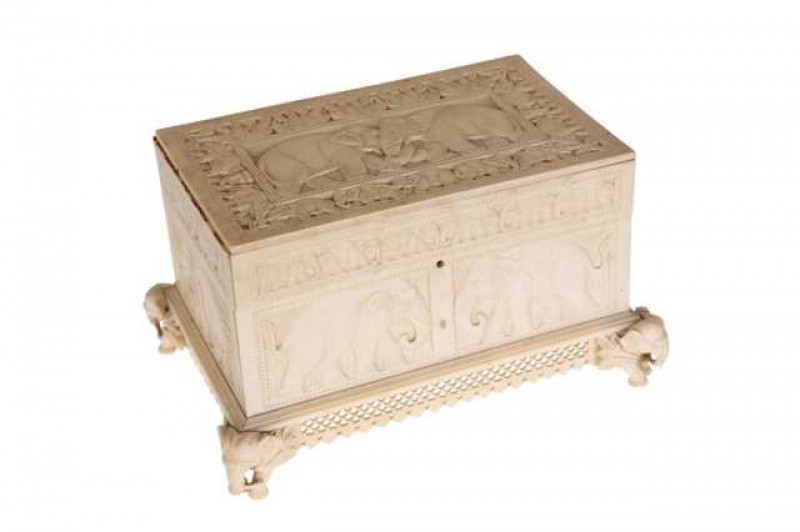An Indian ivory box, circa 1900, of rectangular form, carved throughout with elephants, raised on four elephant carved feet joined by pierced trellis. (a/f) 10.5cm by 18cm by 12.5cm