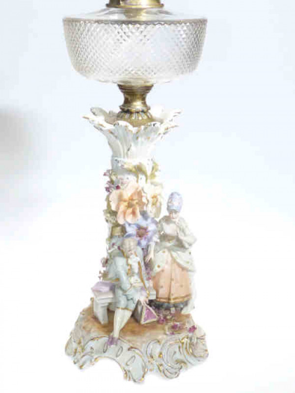 Plaue Continental figure and floral encrusted oil lamp with clear glass reservoir