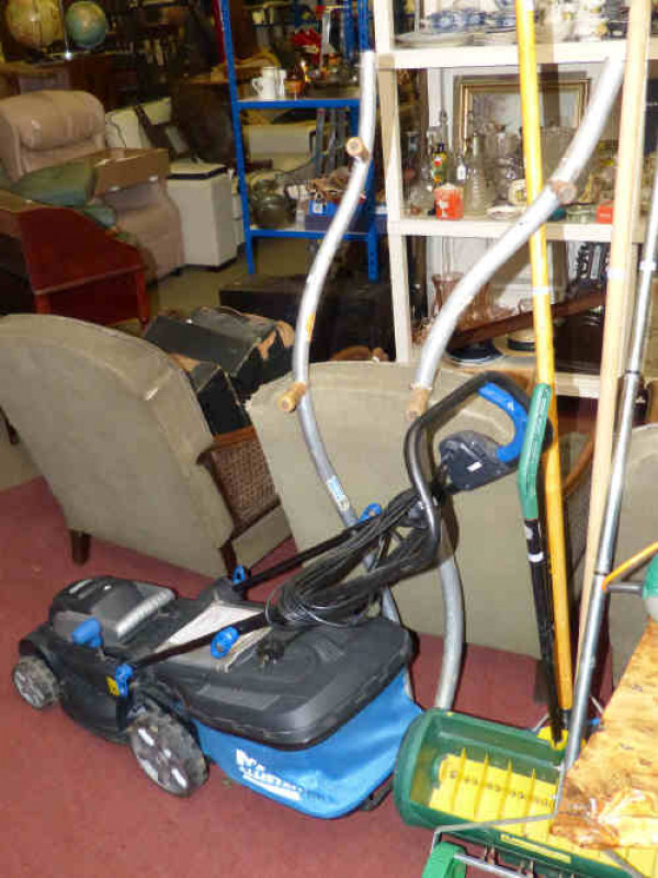 Collection of gardening equipment including MacAllister 1300w lawn mower, Black and Decker hedge trimmer, two scythes, hoe, rake, seed dispenser and lawn spike