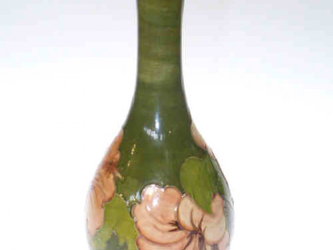Moorcroft hibiscus bottle vase on brushed green ground, bearing initials...