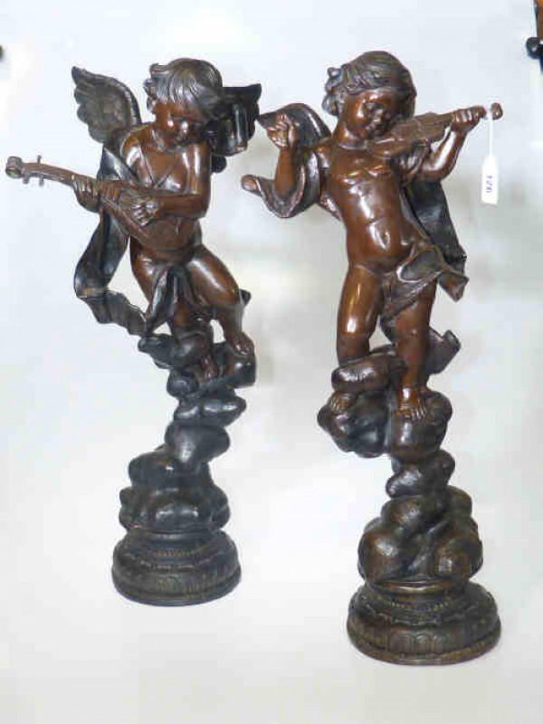 Pair of bronze musical putti each on naturalistic ground playing violin and mandolin, 61cm high