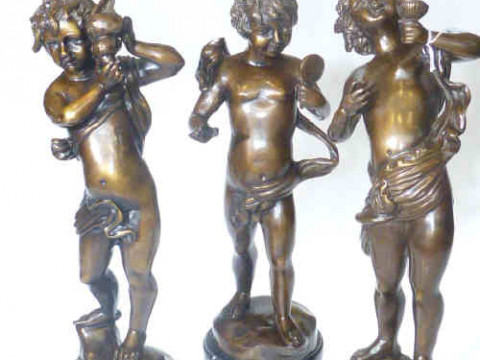 Three bronze models of putti holding conche shell, mirror and wine vessel...