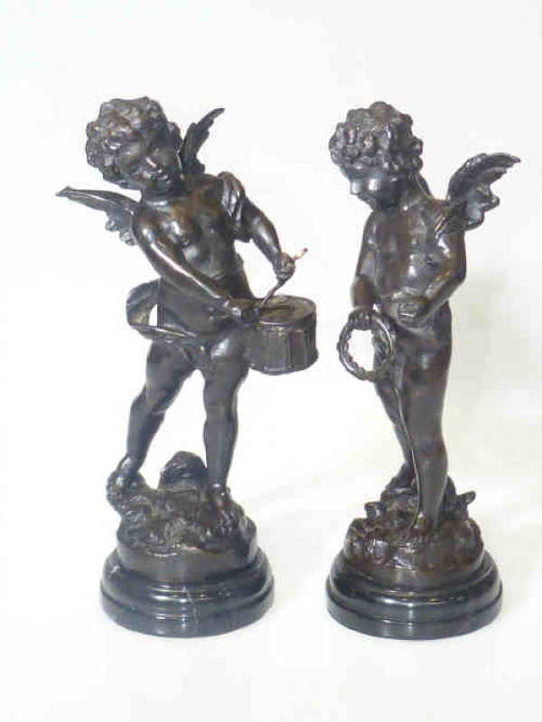 Pair of bronze musical putti playing drum and tambourine, on naturalised ground and stepped marble plinths, 32cm high