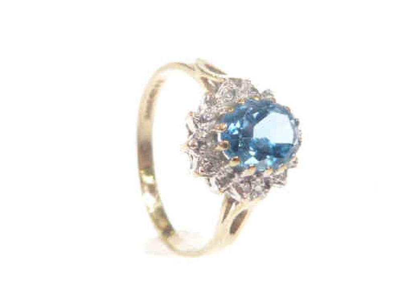 9ct gold ring set with an oval blue topaz within a surround of diamonds, size N
