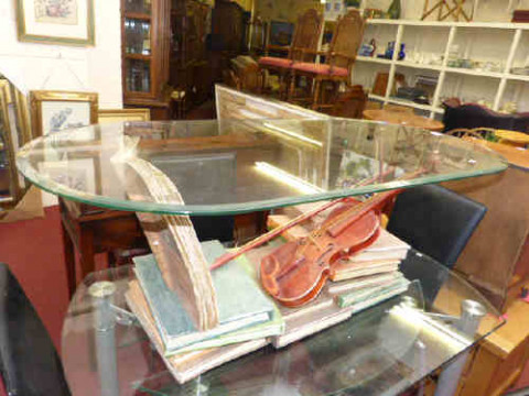 Oval glass topped coffee table on novelty music related stand