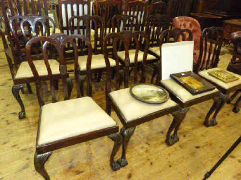 Set of eight shaped rail back dining chairs raised on cabriole legs to ball and claw feet