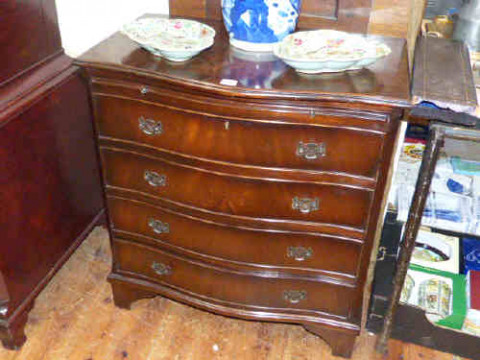 Mahogany serpentine front chest with brush slide above four graduated...