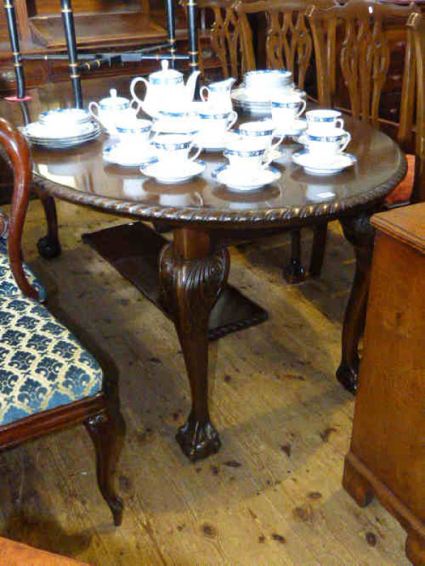 Oval mahogany Chippendale style extending dining table and two leaves together with four chairs to match