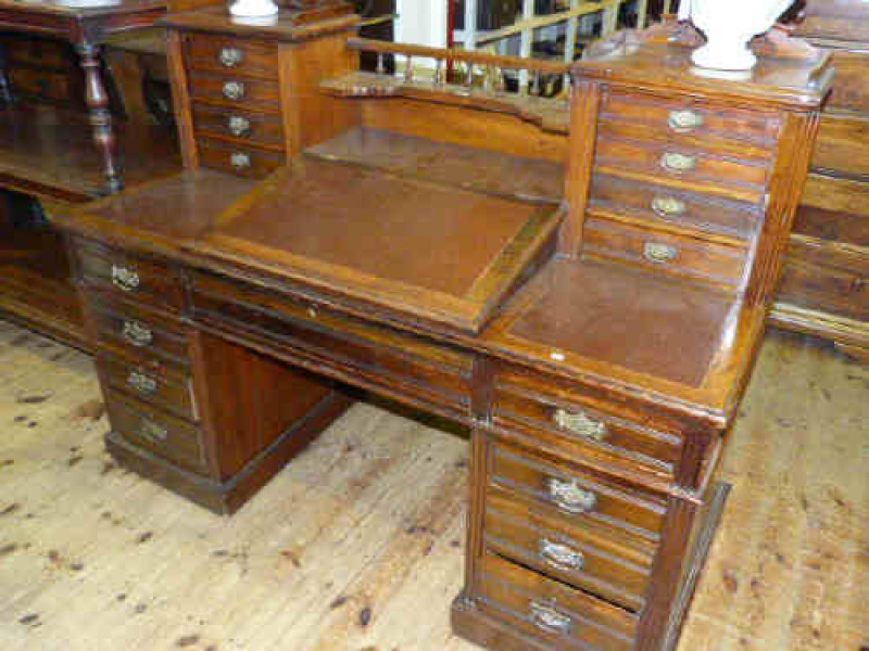 Victorian walnut pedestal desk, the top having slope front centre flanked by two banks of four drawers, with three frieze drawers above a pair of three drawer pedestals