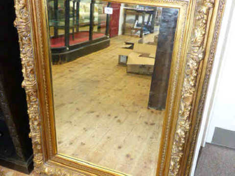 Rectangular ornate gilt framed bevelled wall mirror