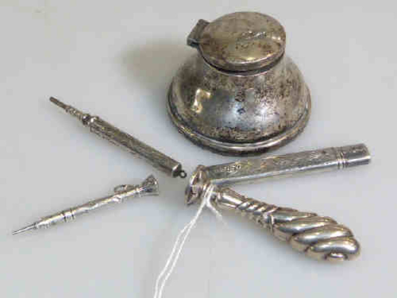 Silver inkwell and three pencils