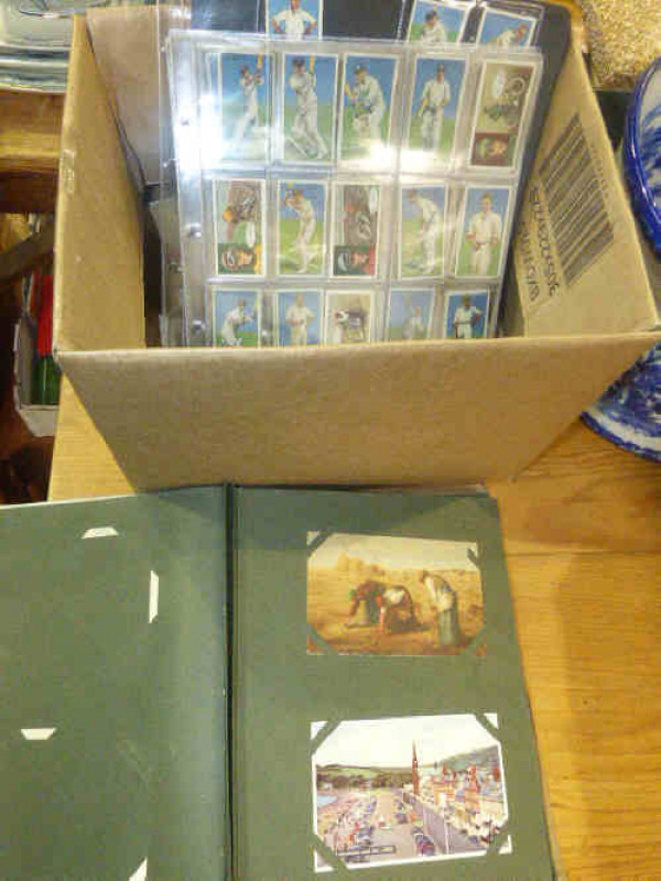 Postcards in album, loose and on leaves, and cigarette cards