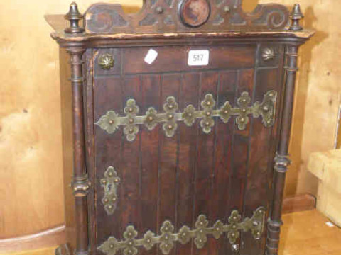 Small stained wood finish wall cabinet with metal strapwork style hinges...