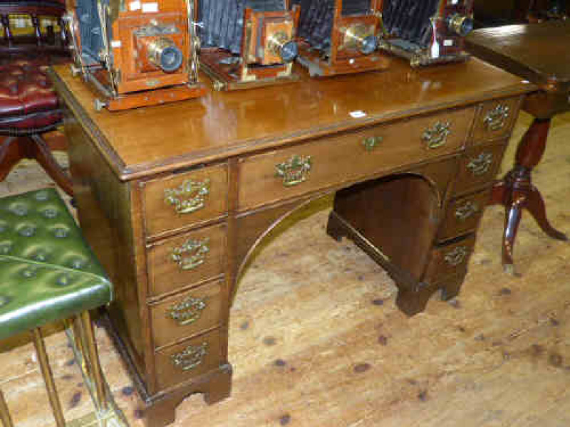 Mahogany kneehole desk with arrangement of brass handled drawers