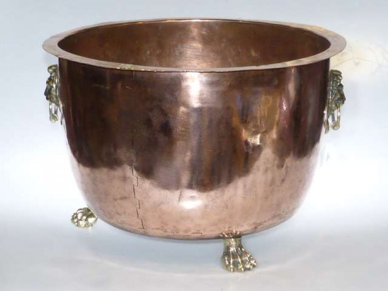 Large copper log bin with lion mask handles raised on three paw feet stamped Geo. Garrard, Saxmundham