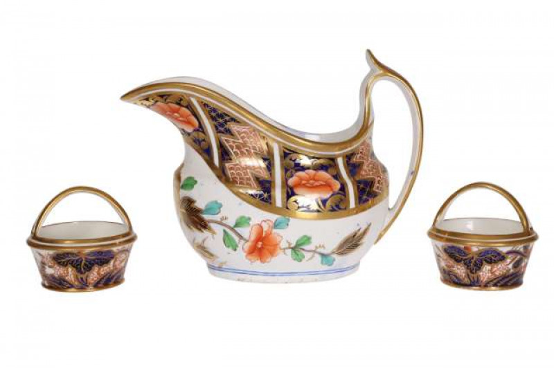 A pair of Spode miniatures, each basket painted in an Imari palette and embellished with gilding, no. 2214; together with a Spode cream jug, similarly decorated. (3) Jug 14.5cm wide