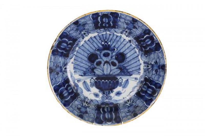 A Dutch Delft 18th Century blue and white dish, De Porceleyne Claeuw factory, painted with the Peacock pattern within an ochre painted rim, blue claw marks. 35cm