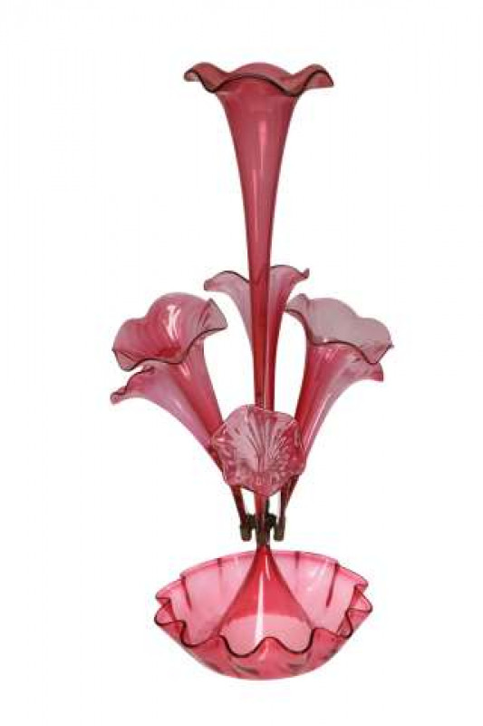 A cranberry glass epergne, the circular base with undulating rim, issuing a tall tapering central vase, encircled by five shorter vases. 65cm