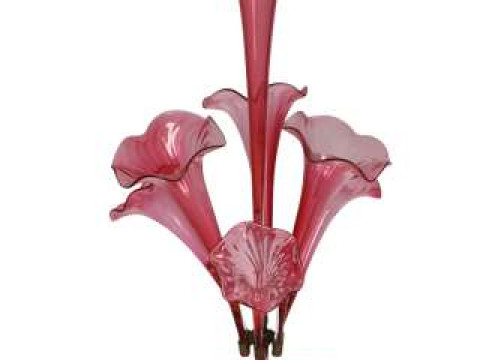 A cranberry glass epergne, the circular base with undulating rim, issuing...