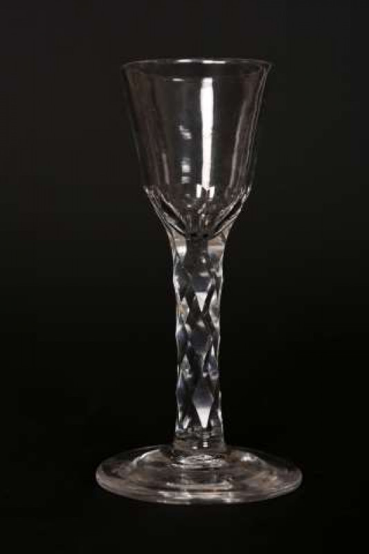 A facet stem wine glass, c.1780, the base of the round funnel bowl crested with small flutes, raised on a circular foot. 15cm