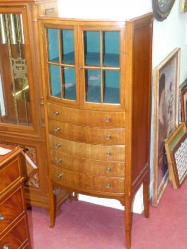 Edwardian mahogany bow front music cabinet having two glazed panel doors above five drop front drawers on splayed legs