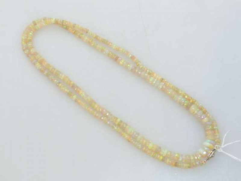 Opal bead necklace, the graduating faceted opals on a 15ct gold, enamel and seed pearl clasp, 80cm, 19 grams