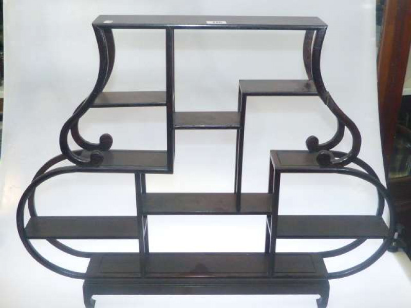 Oriental redwood snuff bottle stand with bentwood supports holding nine shelves
