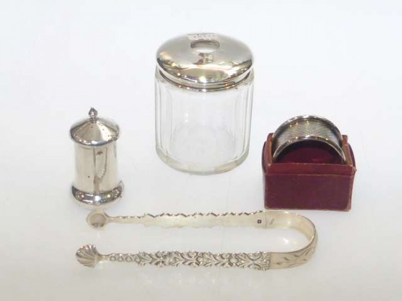 Silver topped and glass hair tidy, silver pepperette, sugar tongs and napkin ring