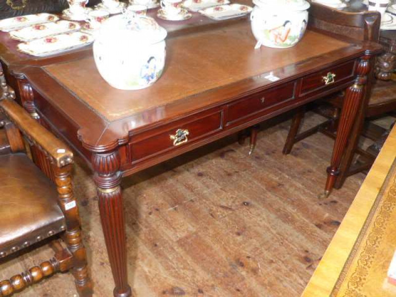 Regency style mahogany three drawer writing table on tapering turned reeded legs