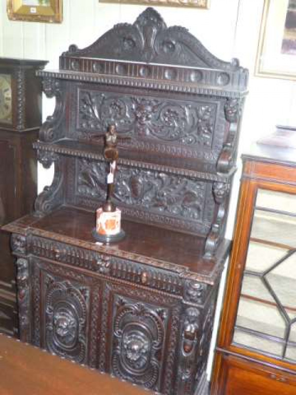 Victorian heavily carved oak two door cabinet having arched shelf back