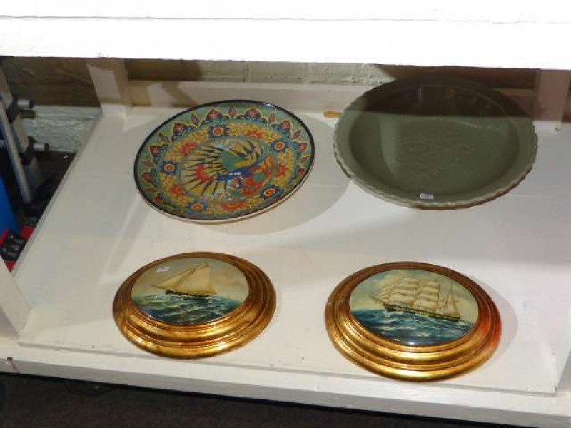Two pottery chargers and two oval gilt framed plaques decorated with stripes