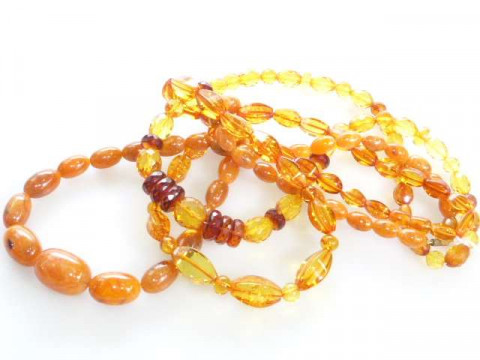 Three strings of amber coloured beads, gross approximately 141 grams