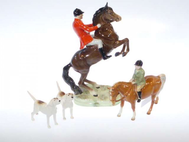 Beswick model of a Huntsman on rearing horse, no. 868, second version, brown; Beswick model of a boy on pony, no. 1500, Palomino; and two Beswick hounds (4)