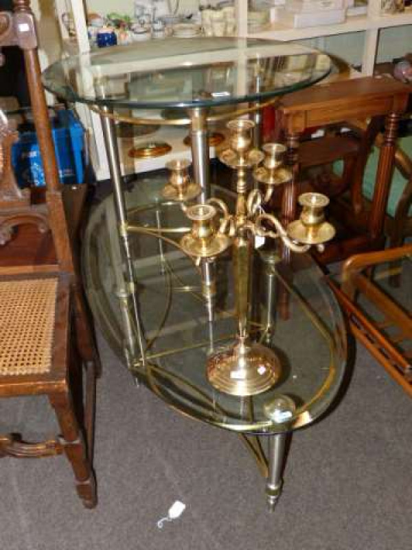 Circular and oval contemporary glass topped coffee tables and four branch brass candelabra (3)
