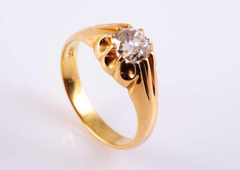 A GENTLEMAN'S DIAMOND SIGNET RING c.1900 The oval mixed cut diamond ten claw set in a raised heavily moulded mount between heavily moulded tapering shoulders on a plain band. Stamped 18CT.  Ring size S. Weight approximately 6.8gms.