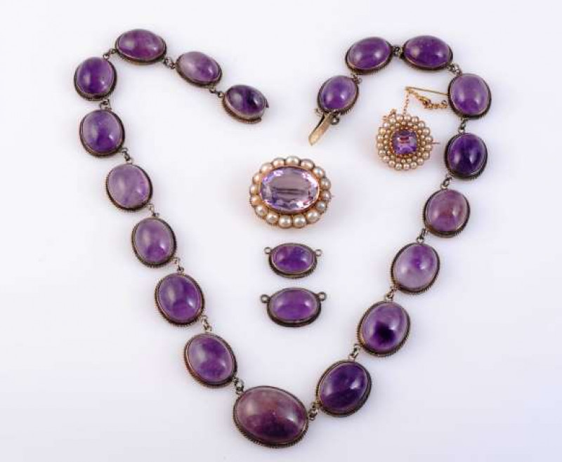 A COLLECTION OF AMETHYST JEWELLERY To include an amethyst necklace, the nineteen oval cabochon cut graduating amethysts all collet set in open mounts with subtle scroll detailing, all joined by a single articulated link, joined with an integral tongue cla