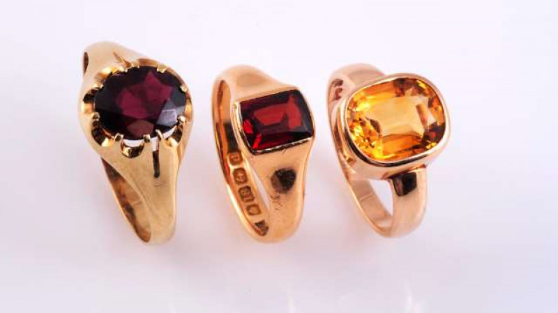 A GARNET AND GOLD SIGNET RING c.1900 The oval cut garnet ten claw set in an open mount between tapering shoulders on a plain band. Stamped 375. Ring size Z. Weight approximately 3.2gms a garnet and gold signet ring, the rectangular cut garnet collet set i