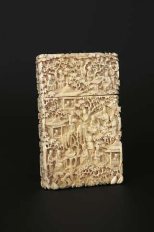 A CHINESE CANTON CARVED IVORY CARD CASE Densely carved with figures and foliage, 19th Century. 11.5cm by 7cm