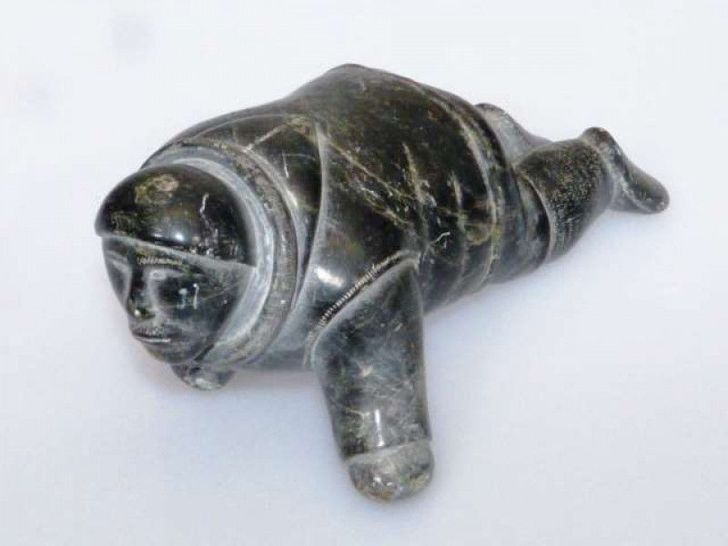 AN INUIT STONE CARVING The green stone carved as a stalking inuit man. 21cm